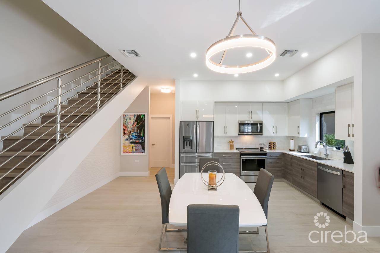 Open concept follows into the dining and kitchen. Modern staircase goes up to two of three bedrooms and the laundry. Fabulous focal wall under the staircase is an eye catching textured tile wall.